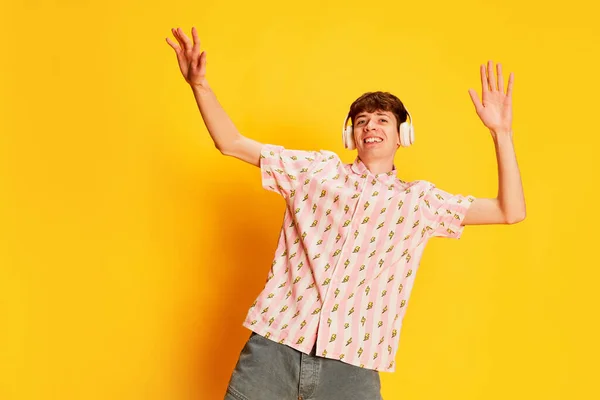 Emocjonalny Uśmiechnięty Mężczyzna Student Słuchawkach Słuchający Muzyki Tańczący Jasnożółtym Tle — Zdjęcie stockowe
