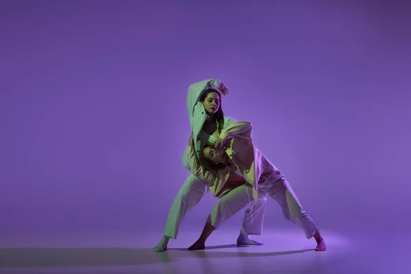 ダンスショー 現代の振付ダンスクラスでスタイリッシュな女性ダンサーのカップルは 結晶紫色の背景に隔離されました 新しいダンススタイル ファッション トレンドの概念 — ストック写真