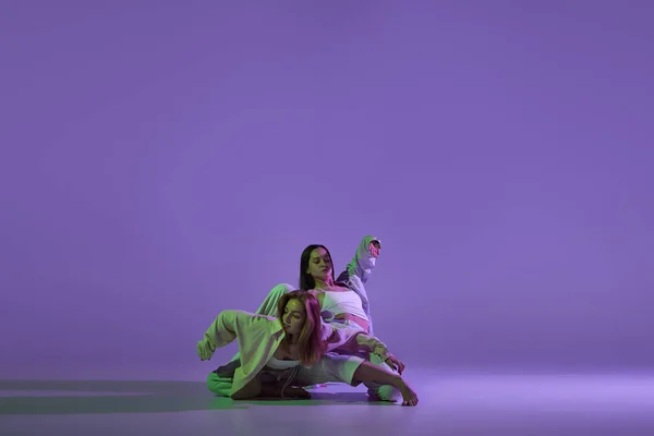 舞蹈表演 在当代编舞课上 一对时髦的女舞蹈家在水晶紫色背景下被隔离在一起 新舞蹈风格 音乐和时尚 趋势的概念 — 图库照片