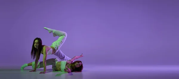 ダンスショー 現代の振付ダンスクラスでスタイリッシュな女性ダンサーのカップルは 結晶紫色の背景に隔離されました 新しいダンススタイル ファッション トレンドの概念 — ストック写真