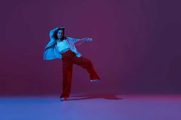 灵活的年轻姑娘 嬉皮笑脸的舞蹈演员 在霓虹灯深紫色背景下孤立地跳嘻哈舞或实验舞 当代舞蹈 年轻人的生活方式 广告的复制空间 — 图库照片
