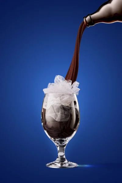 Frothy drink. Imitation of stream of dark stout pours into beer glass over dark blue color background. Concept of creativity, imagination, Oktoberfest, ad. Vertical poster