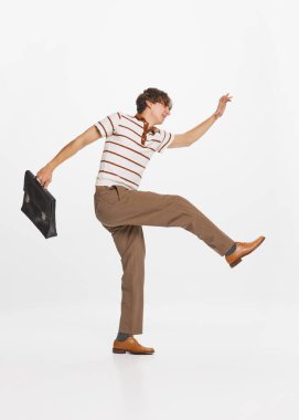 İşadamı, tüccar. Gri arka planda eski moda kıyafetleri içinde mutlu, genç bir adam. Eski moda anlayışı, tarz, olumlu duygular. İlan için alanı kopyala