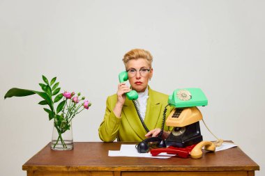 Bayan patron. Modaya uygun, orta yaşlı, modaya uygun, modaya uygun kıyafetleri olan bir kadının aydınlık arka plandaki eski nesnelerin yaratıcı portresi. Moda, akıl sağlığı, reklam, güzellik ve duygu kavramı.