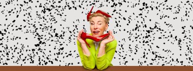 Beautiful emotional fashionable middle age blonde woman with short haircut holding red heels shoes over dalmatian print background. Fashion, aspiration, ad, emotions concept. Banner with copyspace