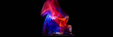 Sportive energetic man, soccer football goalkeeper in action, motion over dark background with mixed neon light. Concept of sport, achievement, competition, goals. Banner, flyer