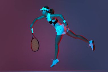 Back view of professional tennis player playing tennis over pink-purple background in neon light. Concept of sport, health, strength, action, motion, lifestyle. Copy space for ad