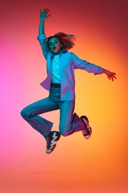 Özgürlük, mutluluk. Neşeli mutlu genç kız, neon ışıklarıyla pembe arkaplanda yüksek oranda zıplıyor. Güzellik anlayışı, gençlik, yüz ifadesi, duygular, yaşam tarzı. İlan için alanı kopyala