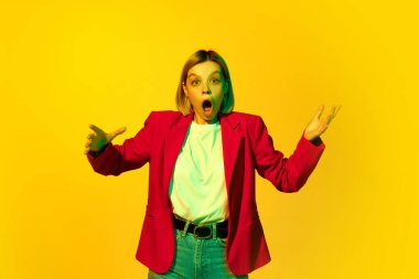 Vay canına, sürpriz, şok. Sarı saçlı, kırmızı ceketli, sarı arka planda canlı bir yüz ifadesi olan genç kız diye bağırıyor. İnsan duyguları, ruh hali, moda, reklam ve ruh sağlığı kavramı