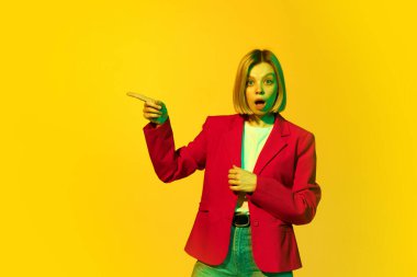 Vay canına, sürpriz, şok. Sarı saçlı, kırmızı ceketli, sarı arka planda canlı bir yüz ifadesi olan genç kız diye bağırıyor. İnsan duyguları, ruh hali, moda, reklam ve ruh sağlığı kavramı