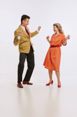 Beyaz arka planda izole edilmiş, eski tarz dans eden şık, güler yüzlü kadın ve erkek. Aşk kavramı, ilişki, eski tarz, yaratıcılık, müzik. İlan için alanı kopyala