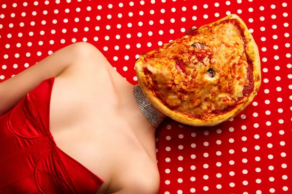 Weird people concept. Young girl lying on table with pizza on her face over red-white background. Vintage, retro style. Complementary colors. Food pop art photography, fashion, kitsch concept