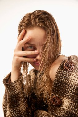 Half-length portrait of young stylish 25s age girl with bare shoulders wearing coat posing isolated over white background. Concept of fashion, trends, beauty, style, youth, ad. Looks adorable