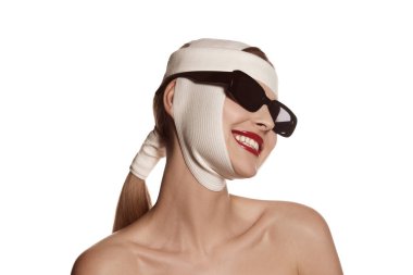 Lifting, therapy. Female face bandaged with medical bandages and sunglasses with human emotions. Making beauty, modifying face to make surgical correction, plastic surgery. correction of asymmetry.