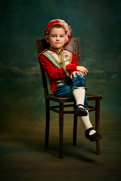 中世のキャラクターとして身を包んだかわいい男の子の肖像画 ダークヴィンテージスタイルの背景 ファッション 演劇芸術の概念をポーズ小さな王子とページボーイ 時代比較 — ストック写真