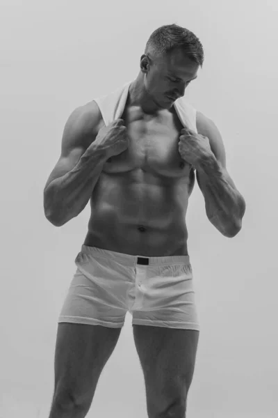 年轻英俊的肌肉发达的男子在灰色的工作室背景下摆出一副赤身裸体的样子 男子气概和力量 男性健康的概念 男性身体的美丽 — 图库照片