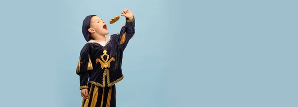 幸せよ 中世のページボーイの衣装でかわいい小さな魅力的な少年 ライトブルーの背景に大きなロリポップと小さな王子 子供の感情 時代の比較 ファッションの概念 バナー — ストック写真