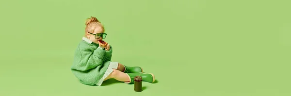幸せな笑顔かわいい子供 ファッショナブルな外観の服やサングラスを身に着けている女の子は明るい緑の背景の上にポーズ 春のファッションコレクション 広告コンセプト モノクローム像 — ストック写真