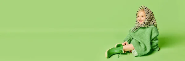 雨の中を歩く 幸せな笑顔かわいい子供 ファッショナブルな外観の服や薄緑の背景にガンブーツの女の子 春のファッションコレクション 広告コンセプト バナー — ストック写真
