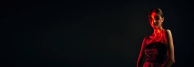 Karanlık mod arka planında dijital neon filtre ışıkları olan genç ve şehvetli bir kadının yaratıcı portresi. Dijital sanat, moda, siber punk, fütürizm ve yaratıcılık kavramı. Kopyalama alanı olan pankart