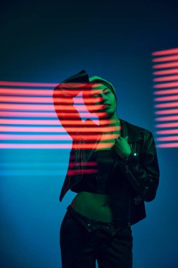 Kırmızı çizgiler. Genç ve şık bir kadının yarım boy portresi koyu mavi arka planda, neon ışıklı çizgilerle poz veriyor. Çağdaş sanat, moda, siber punk, fütürizm kavramı