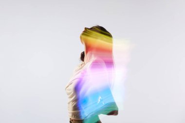 Heves. Beyaz arka planda poz veren sevimli bir genç kadının silüet portresi. Vücudunda karışık neon renkli bir ışık var. Çağdaş sanat, güzellik, moda, fütürizm kavramı