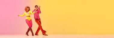 Pembe-sarı arka planda dans eden, retro tarzı kıyafetler içindeki etkileyici, heyecanlı profesyonel dansçılar. 70 'ler, 80' ler moda tarzı, müzik ve duygular. Kopyalama alanı olan pankart
