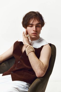 Sakinlik ve kendine güven. Gri arka planda soyutlanmış bir şekilde poz veren şık, yüksek moda bir çocuğun portresi. Erkeklik ve kadınlık. Modern moda kavramı, eşsizlik, reklam