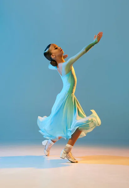 华尔兹穿着舞台服装的灵活小女孩的画像 蓝色背景下的舞衣交际舞 美的概念 专业的舞蹈 运动中的情感 — 图库照片