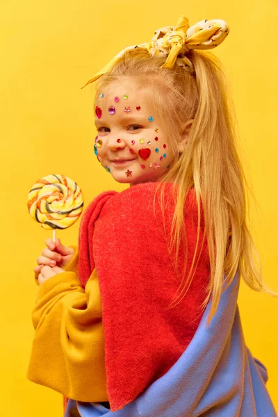 Élvezem Boldogságot Fénykép Kislányról Aki Nyalókát Tart Mosolyog Sárga Háttér — Stock Fotó
