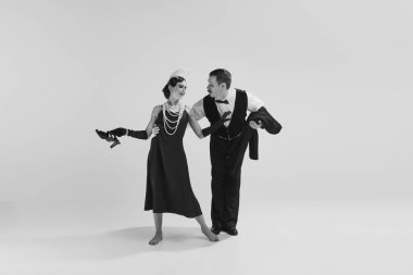 Partiden sonra. Sevimli dansçılar klasik kıyafetler giyip aşktan bahsediyorlar. Aşk ve müzik konsepti. Retro tarzı, tek renkli. Siyah beyaz fotoğraf.