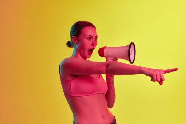 Lütfen dikkat. Sarı-turuncu arka planda, neon ışıkta hoparlörden bağıran ve çığlık atan etkileyici genç kız. Güzellik kavramı, insani duygular, satış, haber, ruh hali, reklam