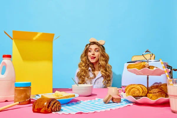 American breakfast, cereals, peanut butter, milk. Vintage, retro style. Food Food pop art photography. Image of cute woman want eating sweet breakfast, showing tongue out over light blue background