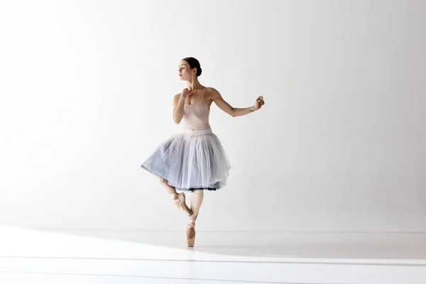 Inspired beautiful ballerina dancing and looking away over white background. Concept of classic ballet, inspiration, beauty, dance, creativity. Beauty of contemporary dance