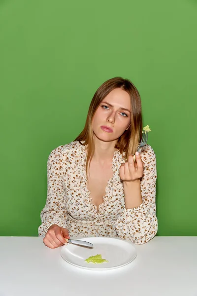 厌食症和饮食紊乱的概念 一个精疲力竭的年轻女子的画像 平平淡淡地放在盘子里 吃着青葱的背景 美容美发 模范企业 饮食失调的概念 — 图库照片