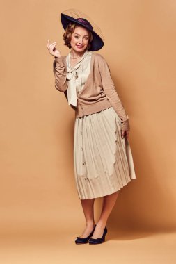 Kurnaz. Klasik kıyafetler giymiş, bej arka planda kurnaz bir yüz ifadesi olan bir kadının fotoğrafı. İnsan duygularını kavra, güzellik, moda, retro stil, vintage, 60 'lar