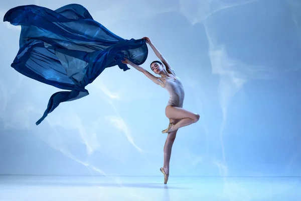 動きの美学 青い背景の上に絹の生地でポーズ魅力的なバレリーナ 絹のバレエ 古典バレエ インスピレーション 美しさ ダンス 創造性の概念 — ストック写真