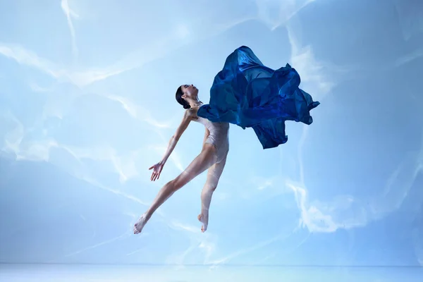 羽のように軽い 青い背景にシルク生地で美しいジャンプバレリーナのショット 絹のバレエ 人間の感情 ダンス 演劇の概念 現代バレエ — ストック写真