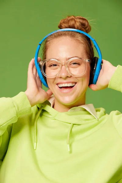 소녀가 웃는다 안경을 헤드폰을 음악을 배경에 소녀를 감싼다 광고와 음악에 — 스톡 사진