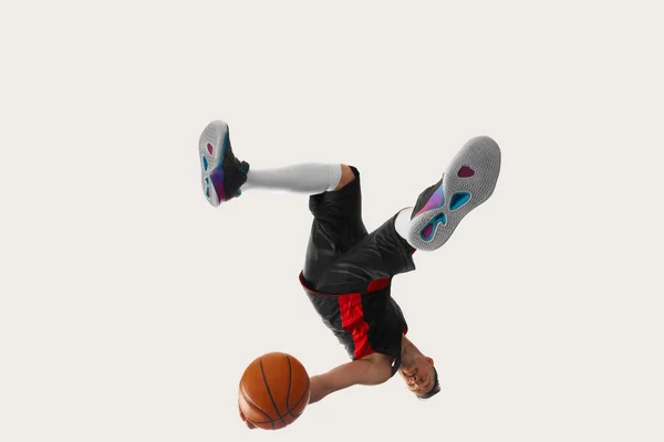 動きの開発 運動中のボールと一様スポーツのプロバスケットボール選手のイメージ 白いスタジオの背景にアクション スポーツの概念 — ストック写真