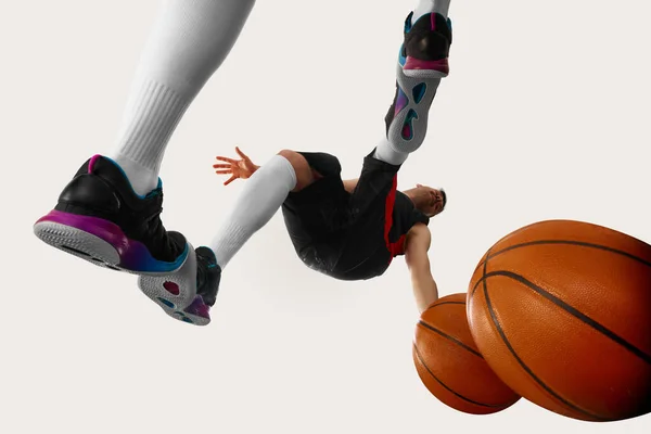 バスケットボールの試合だ スポーツのユニフォームを着て白い背景の上にボールで動く1人の若いストリートボールプレーヤーのショット 一番下だ スポーツの概念 — ストック写真
