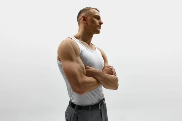 布劳尼 一个肌肉发达的年轻人 双手交叉地站在那里 从白色的工作室背景眺望远方 男性健康 身体护理 健身的概念 — 图库照片