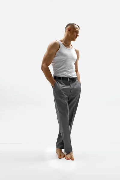 帅呆了迷人的肌肉男子穿着经典的裤子和T恤 手挽手在白色工作室背景口袋里的肖像 男性健康 身体护理 健身的概念 — 图库照片