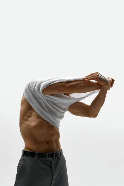 在白色工作室背景下 肌肉发达的男模特脱下T恤衫的肖像 男人装扮成赤身裸体男人味男子健康 美容美发 身体和皮肤护理 健康的概念 — 图库照片
