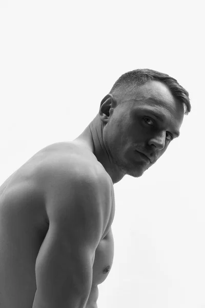 stock image Muscular body shape. Portrait of handsome man shirtless looking at camera with calm facial expression. Monochrome. Concept of men fashion, style, body aesthetics, beauty, mens health, emotions