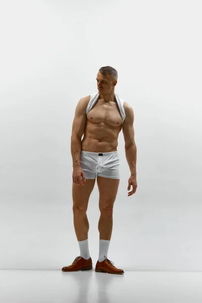 完美的身体 肌肉发达的体形 年轻英俊的肌肉发达的男子在灰色的工作室背景下摆出一副赤身裸体的样子 男子气概和力量 男性健康 男性身体美丽的概念 — 图库照片