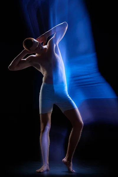 動作中の男性の体 下着姿の若い男の肖像画や暗い背景の上に動きにポーズ 混合ネオンライト 未来主義 シュルレアリスム ファッション サイバー — ストック写真