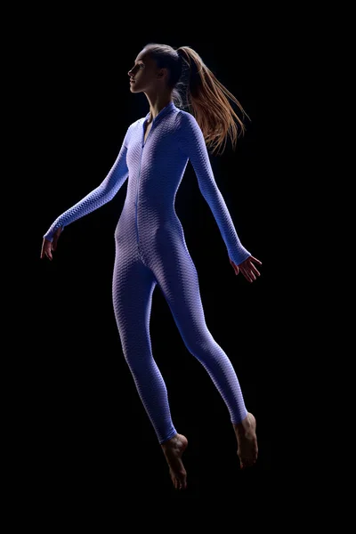 女性身体悬浮 拍的年轻漂亮的女人穿着西服在黑暗的背景下跳上天空 未来主义 超现实主义 美的概念 — 图库照片