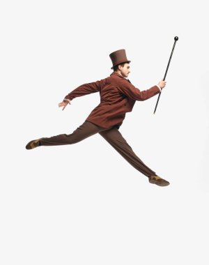 Uçan adam. Eski kıyafetler giyen ve siyah silindirli beyaz stüdyo arka planında bastonla zıplayan bir beyefendinin portresi. Tarihi yeniden yapılanma kavramı, çağların karşılaştırılması, eski, moda