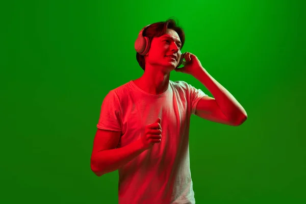 最喜欢的 横幅与一个有吸引力的家伙戴耳机听音乐与绿色霓虹灯背景享受脸 业余爱好 广告的概念 — 图库照片